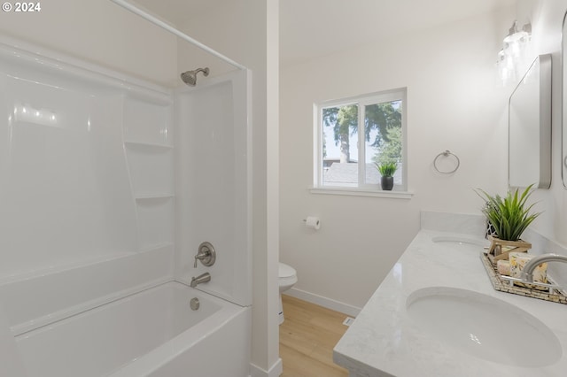 full bathroom featuring oversized vanity, toilet, hardwood / wood-style flooring, shower / tub combination, and dual sinks