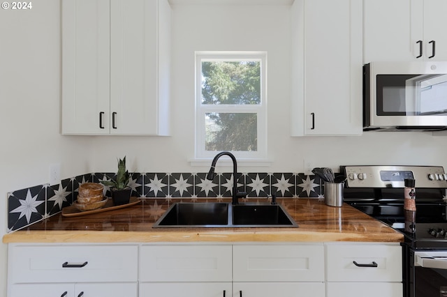 kitchen featuring appliances with stainless steel finishes, sink, and white cabinets