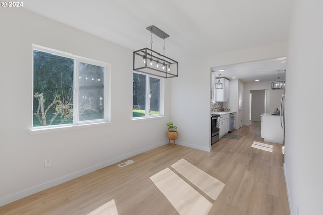 interior space with light hardwood / wood-style floors and a notable chandelier