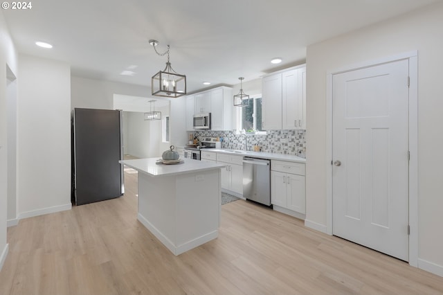 kitchen featuring white cabinets, light hardwood / wood-style flooring, pendant lighting, and stainless steel appliances