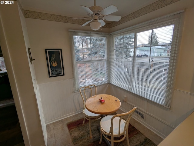 tiled dining space with ceiling fan and a wealth of natural light