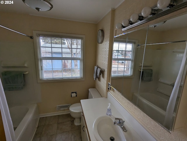 bathroom with tile patterned floors, plenty of natural light, vanity, and toilet