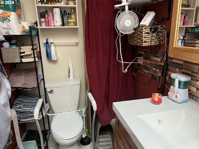 bathroom with tile flooring, toilet, and vanity