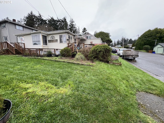 view of yard with a deck, a garage, and an outdoor structure