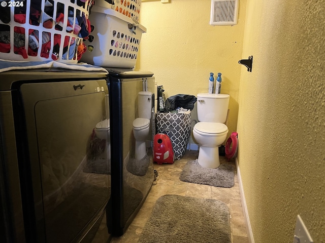 clothes washing area featuring washing machine and clothes dryer and light tile flooring