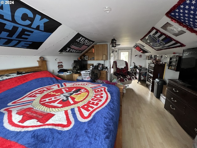 bedroom with lofted ceiling and light hardwood / wood-style floors