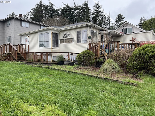 rear view of house with a deck and a lawn