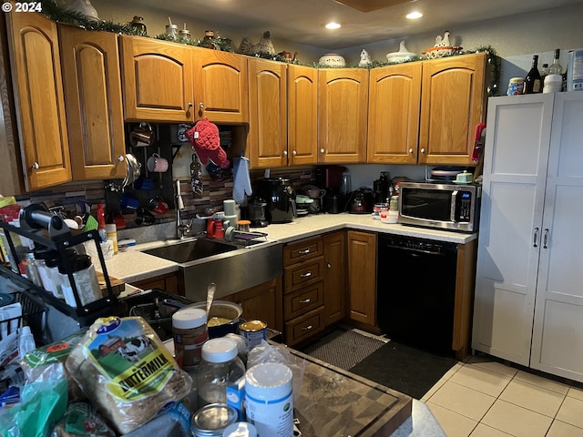 kitchen featuring light tile floors, dishwasher, and sink