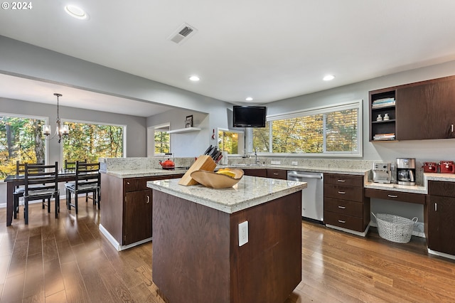 kitchen with pendant lighting, a kitchen island, dark brown cabinets, stainless steel dishwasher, and wood-type flooring