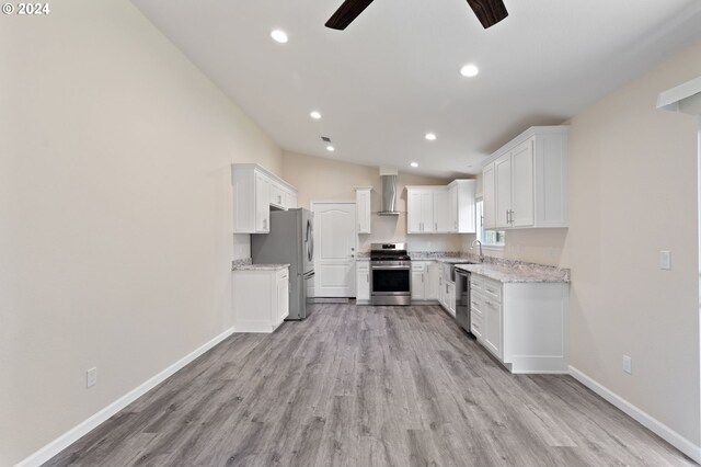 kitchen with white cabinets, wall chimney exhaust hood, sink, and stainless steel appliances