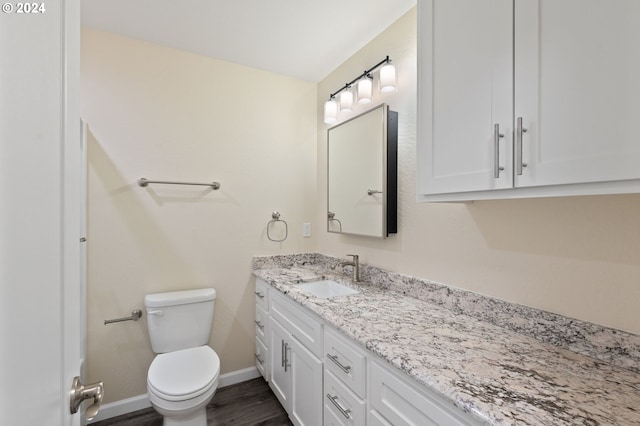 bathroom with hardwood / wood-style floors, vanity, and toilet