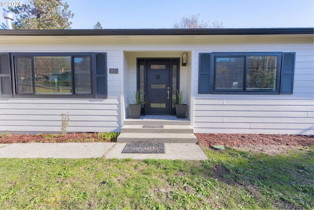 doorway to property featuring a lawn