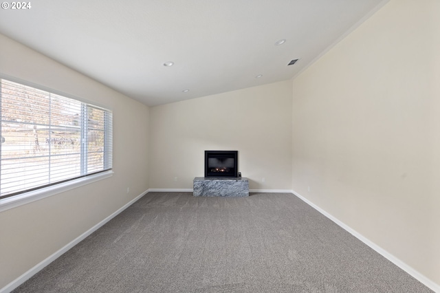 unfurnished living room featuring carpet and lofted ceiling