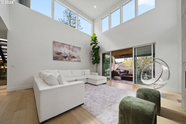 living room with light hardwood / wood-style floors and a high ceiling