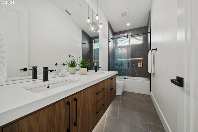 full bathroom with an inviting chandelier, tile patterned floors, bath / shower combo with glass door, vanity, and toilet