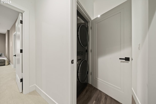 laundry area with stacked washer / dryer and hardwood / wood-style floors