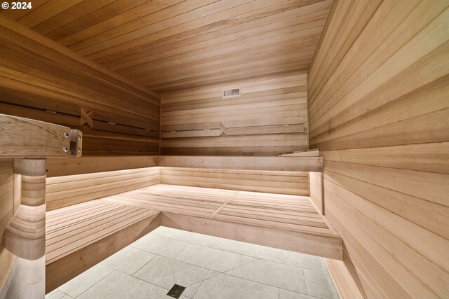 view of sauna / steam room with wood ceiling, wood walls, and tile patterned floors