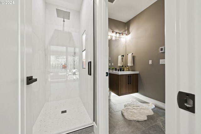 bathroom featuring tile patterned flooring, vanity, and a shower with door