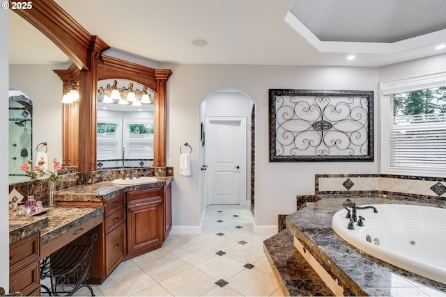 bathroom featuring tile patterned flooring, vanity, and tiled tub