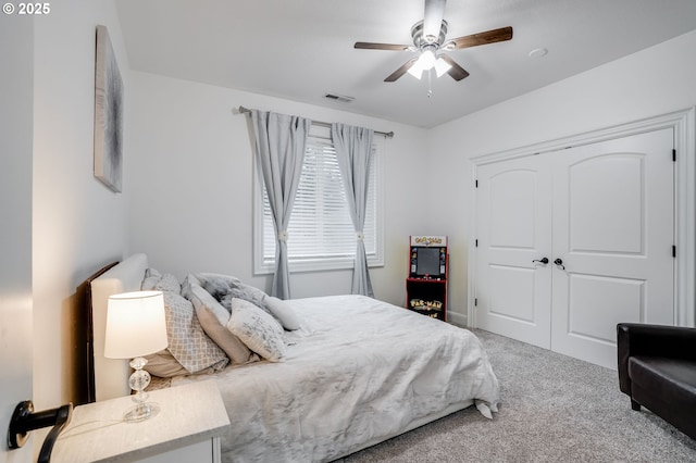 carpeted bedroom with ceiling fan and a closet