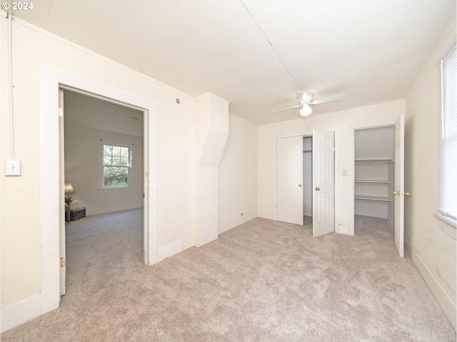 unfurnished bedroom featuring ornamental molding, ceiling fan, and light colored carpet