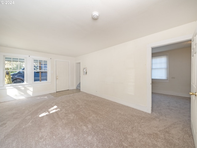 unfurnished living room featuring light carpet