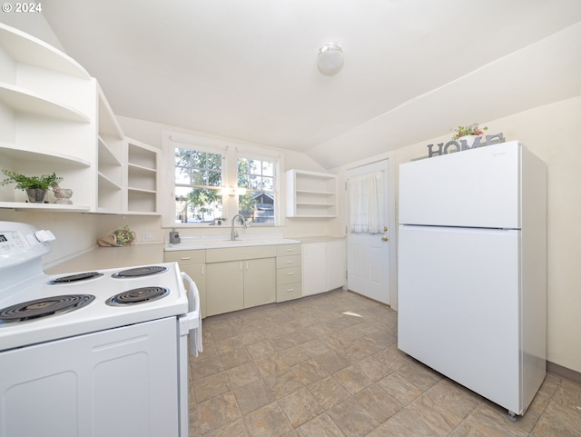 kitchen featuring white appliances, vaulted ceiling, and white cabinetry