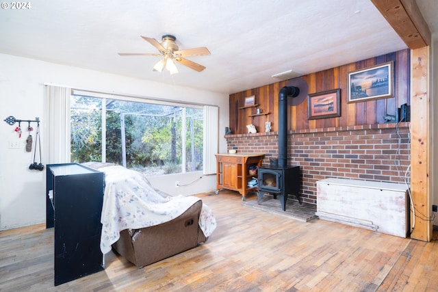 living room with wood walls, light wood-type flooring, and a wood stove