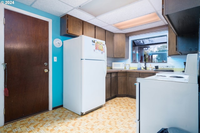 kitchen featuring sink, a paneled ceiling, and white appliances