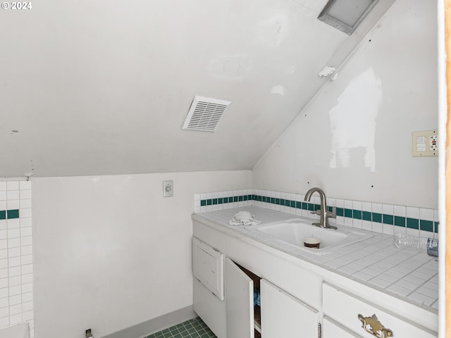 bathroom featuring vaulted ceiling and sink