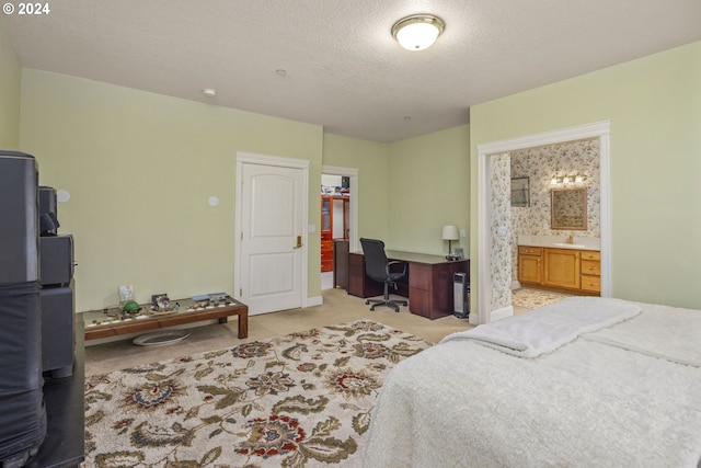 carpeted bedroom with a textured ceiling, ensuite bath, and a closet