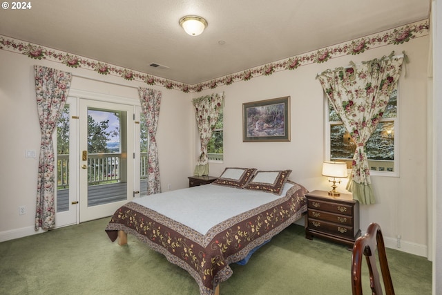 carpeted bedroom with a textured ceiling and access to outside