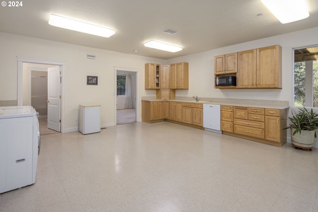 kitchen featuring a textured ceiling, sink, light brown cabinets, dishwasher, and washer / clothes dryer