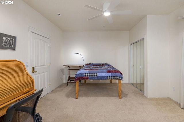 carpeted bedroom featuring ceiling fan and a closet