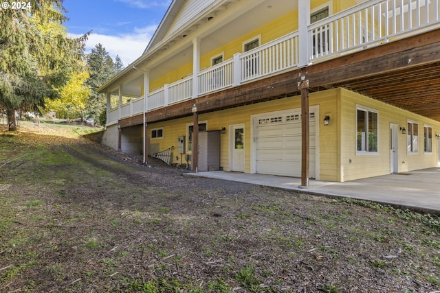 rear view of property with a garage and a patio