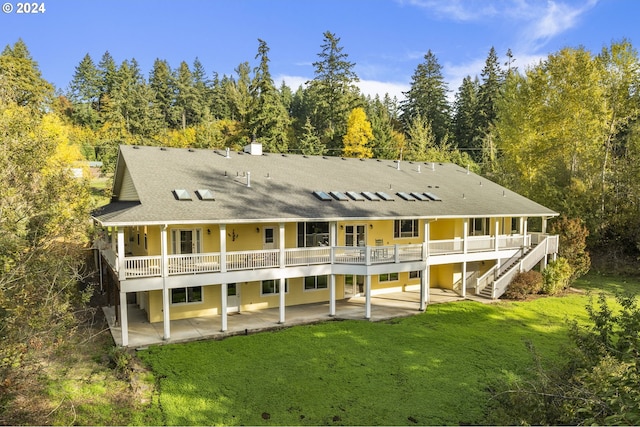 back of property featuring a yard, a deck, and a patio area