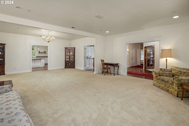 living room featuring light carpet and an inviting chandelier