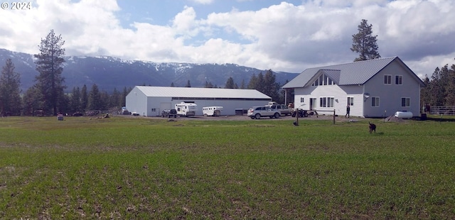 back of house with a mountain view and a yard