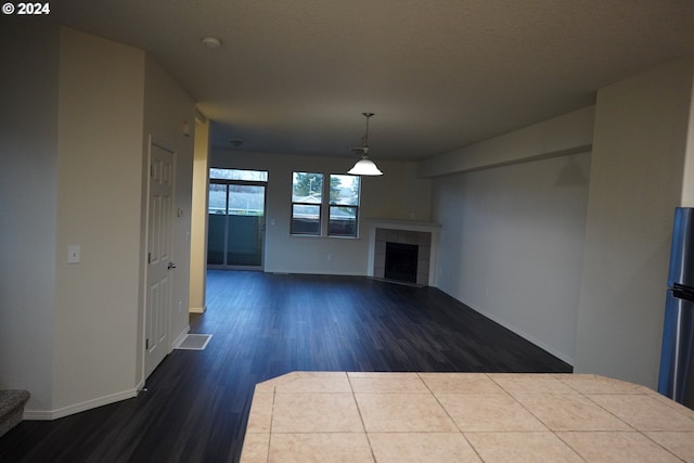 unfurnished living room with a tile fireplace and hardwood / wood-style floors