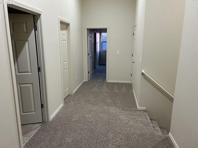 hallway featuring dark colored carpet