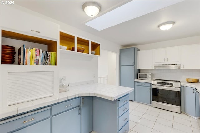 kitchen with backsplash, white cabinetry, light tile patterned floors, stainless steel electric range, and tile counters