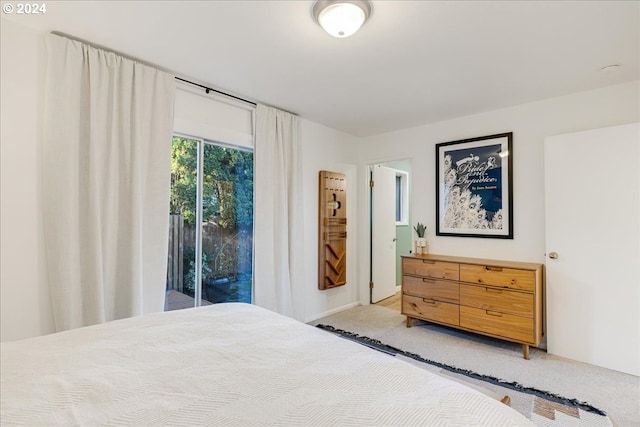 bedroom featuring access to exterior and light carpet