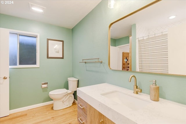 bathroom with hardwood / wood-style floors, toilet, and vanity