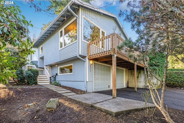 back of house with a garage and a wooden deck