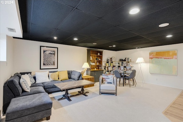 living room with wood-type flooring and a drop ceiling