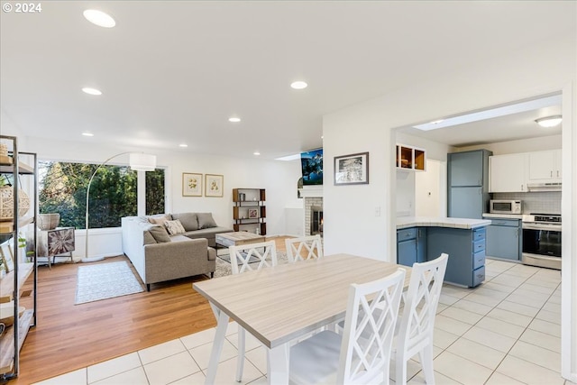 dining area with light tile patterned flooring and a fireplace