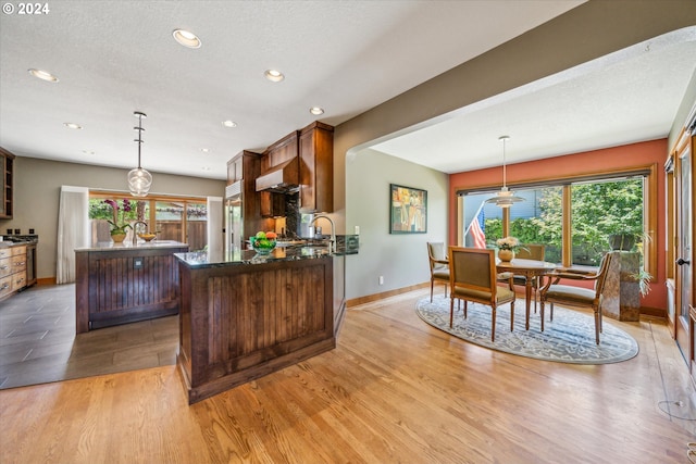 kitchen with light hardwood / wood-style flooring, a kitchen island, and hanging light fixtures