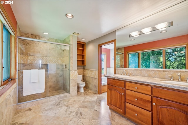 bathroom featuring tile walls, vanity, an enclosed shower, and toilet