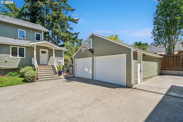 view of front of house featuring a garage and an outbuilding