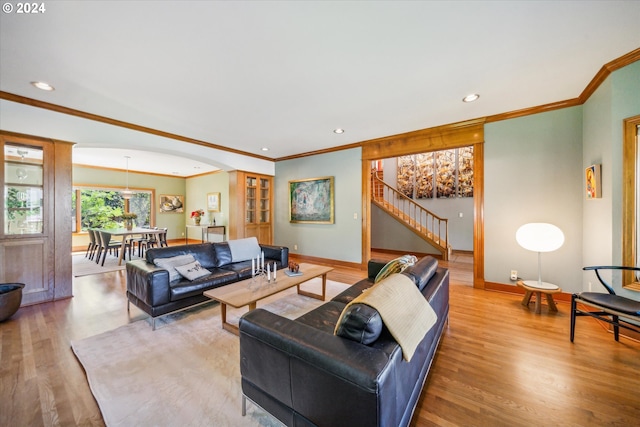 living room with light hardwood / wood-style floors and crown molding